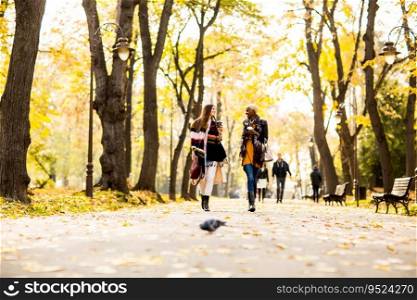 Multiracial female friends walking in teh autumn park