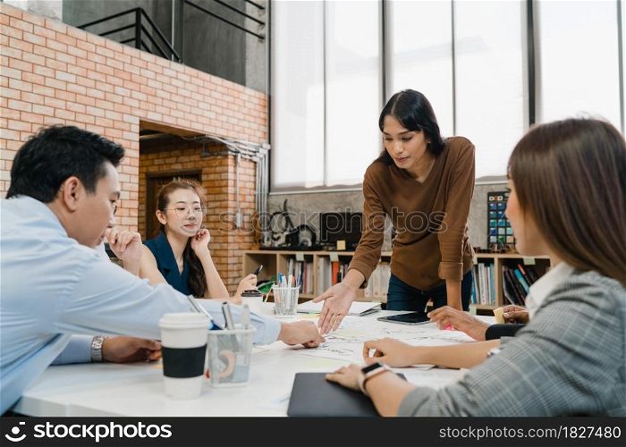 Multiracial group of young creative people in casual wear meeting brainstorming ideas about new paperwork project colleagues working together planning success strategy enjoy teamwork in small office