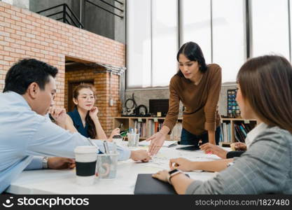 Multiracial group of young creative people in casual wear meeting brainstorming ideas about new paperwork project colleagues working together planning success strategy enjoy teamwork in small office