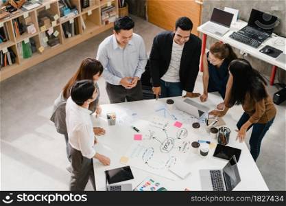 Multiracial group of young creative people in smart casual wear discussing business brainstorming meeting ideas mobile application software design project in modern office. Coworker teamwork concept.