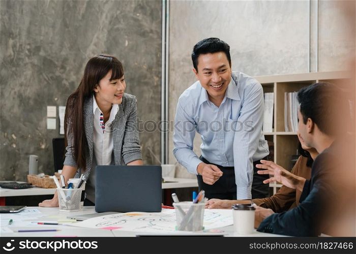 Multiracial group of young creative people in smart casual wear discussing business brainstorming meeting ideas mobile application software design project in modern office. Coworker teamwork concept.