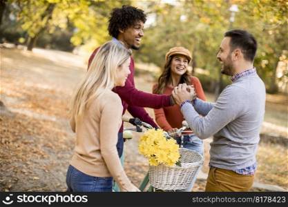 Multiracial young people walking in the autumn park and having fun