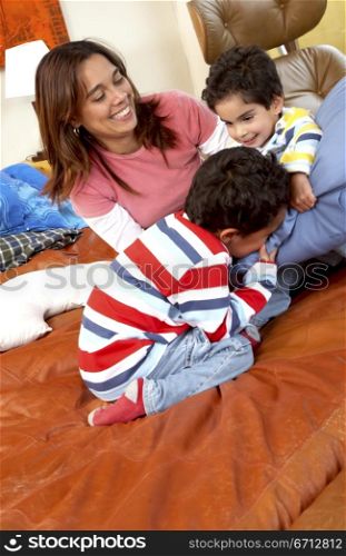 mum with her two kids having fun in the bedroom