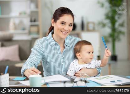 mum working from home with baby on her lap