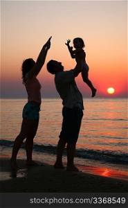 Mummy with daughter and grandfather on sunset ashore