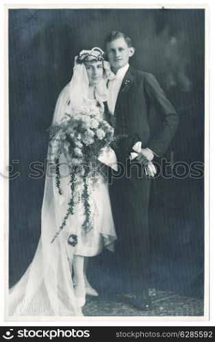 MUNICH, GERMANY - CIRCA 1930: antique wedding photo. portrait of just married couple. bride and groom wearing vintage clothing. nostalgic picture