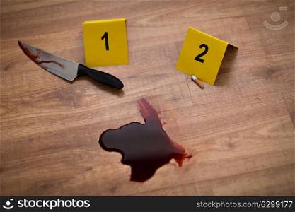 murder, kill and forensic concept - knife in blood and evidence marker at crime scene. knife in blood and evidence marker at crime scene
