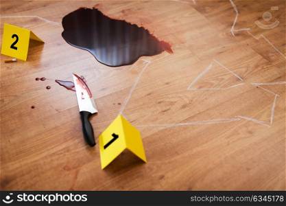 murder, kill and forensic evidence concept - chalk outline of body and knife in blood lying on floor at crime scene (staged photo). chalk outline and knife in blood at crime scene