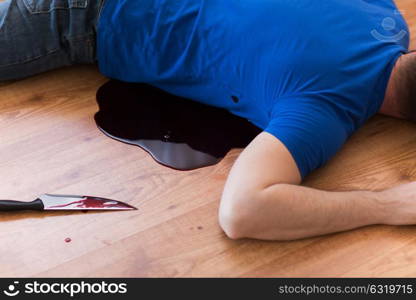 murder, kill and people concept - dead man body and knife in blood lying on floor at crime scene. dead man body lying on floor at crime scene