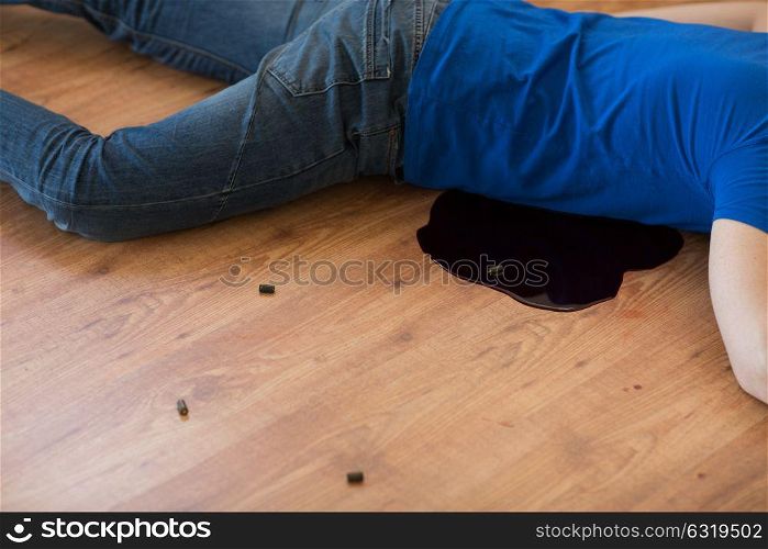 murder, kill and people concept - dead man body in blood lying on floor and bullet sleeves at crime scene. dead man body in blood on floor at crime scene