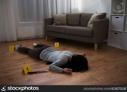 murder, kill and people concept - dead woman body and knife in blood lying on floor at crime scene (staged photo). dead woman body lying on floor at crime scene