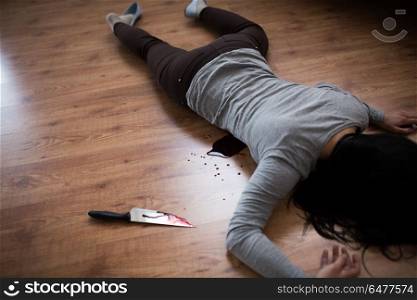 murder, kill and people concept - dead woman body and knife in blood lying on floor at crime scene (staged photo). dead woman body lying on floor at crime scene. dead woman body lying on floor at crime scene