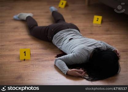 murder, kill and people concept - dead woman body in blood lying on floor and bullet sleeves at crime scene (staged photo). dead woman body in blood on floor at crime scene. dead woman body in blood on floor at crime scene