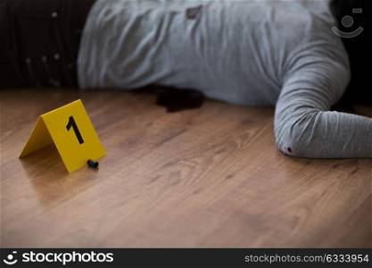 murder, kill and people concept - dead woman body in blood lying on floor and bullet sleeve at crime scene (staged photo). bullet and dead woman body on floor at crime scene