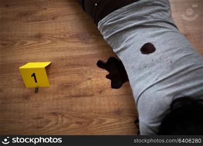 murder, kill and people concept - dead woman body in blood lying on floor and bullet sleeves at crime scene (staged photo). dead woman body in blood on floor at crime scene