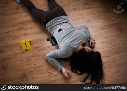 murder, kill and people concept - dead woman body in blood lying on floor and bullet sleeves at crime scene (staged photo). dead woman body in blood on floor at crime scene. dead woman body in blood on floor at crime scene
