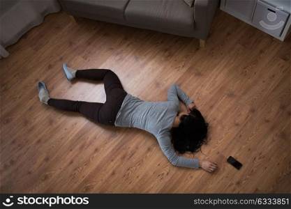 murder, kill and people concept - unconscious or dead woman body and smartphone lying on floor at crime scene (staged photo). dead woman body lying on floor at crime scene