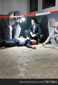 Murder scene with two forensic analysts and a police lieutenant investigating a crime on a businessman in a basement