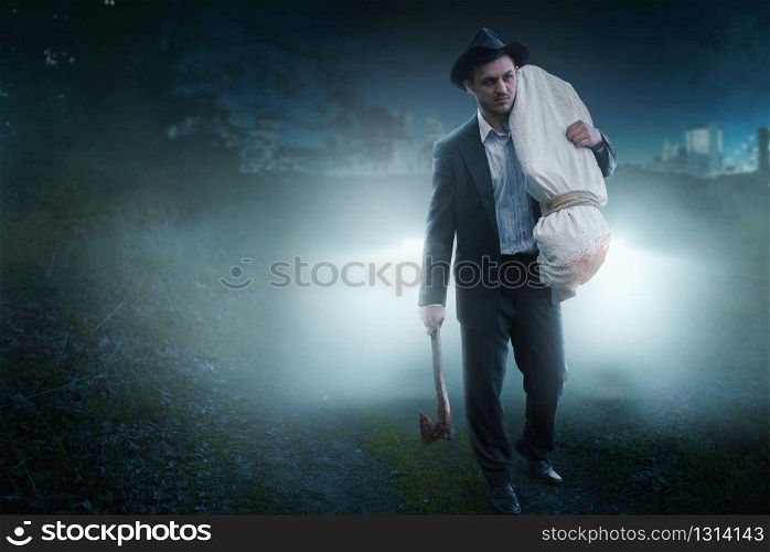 Murderer with an axe carries the victim&rsquo;s body wrapped in a canvas into the night forest, serial maniac concept