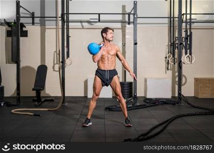 Muscular athletic bodybuilder fitness model posing after exercises in gym. High quality photo. Muscular athletic bodybuilder fitness model posing after exercises in gym.