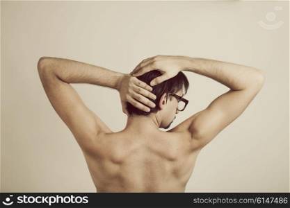 Muscular back of young man wearing glasses on white