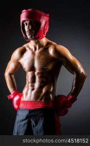 Muscular boxer in dark studio
