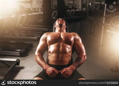 Muscular male bodybuilder training with dumbbells in sport gym. Bodybuilding workout. Power lifting. Male bodybuilder training with dumbbells in gym