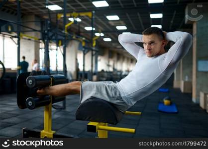 Muscular man doing abs exercise, fitness training in gym. Athletic male person on workout, sportsman in sport club, active healthy lifestyle, physical wellness. Muscular man doing abs exercise, training in gym