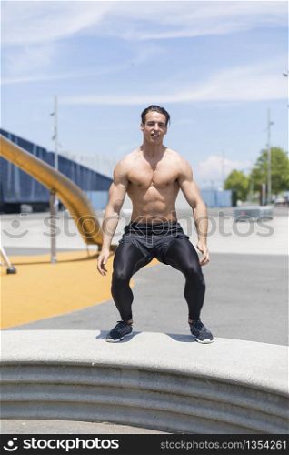 Muscular man doing box jumps outdoors.