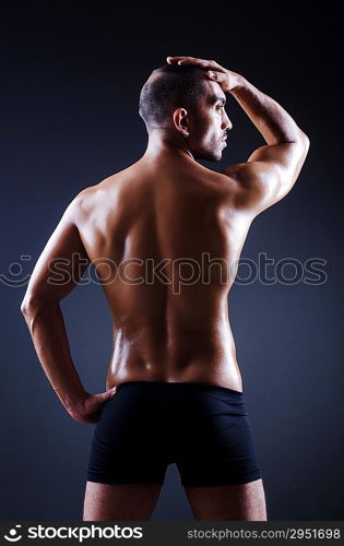 Muscular man in dark studio