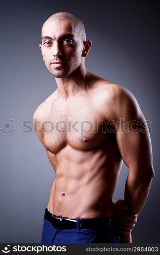 Muscular man in dark studio