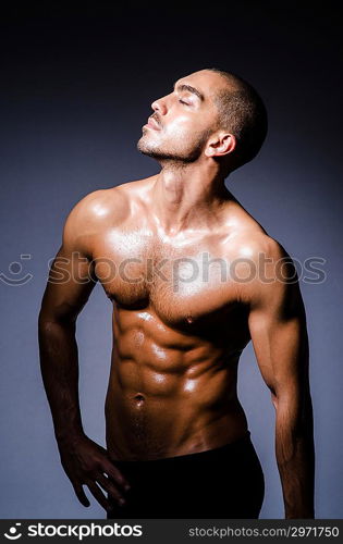 Muscular man in dark studio