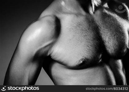 Muscular man in dark studio