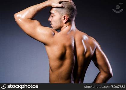 Muscular man in dark studio