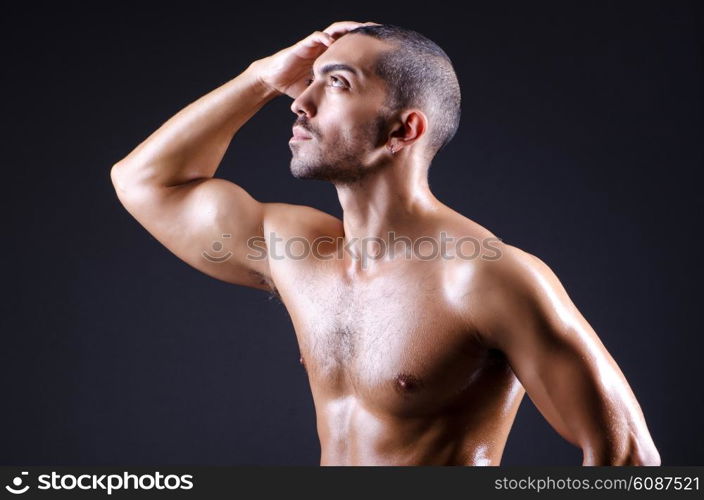 Muscular man in dark studio