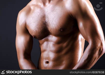 Muscular man in dark studio