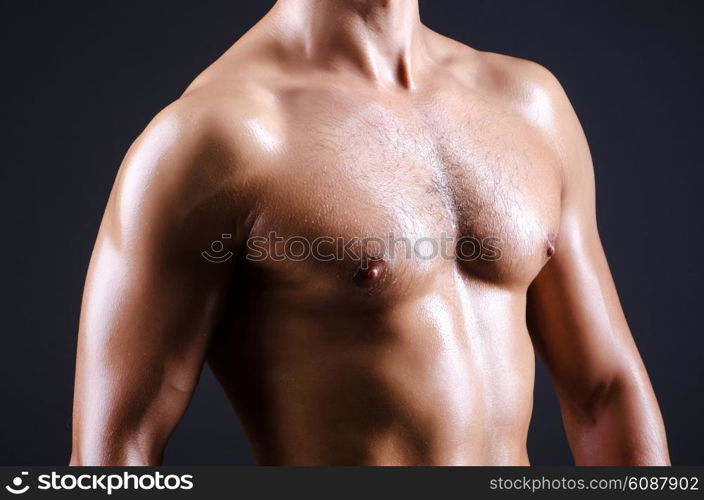 Muscular man in dark studio