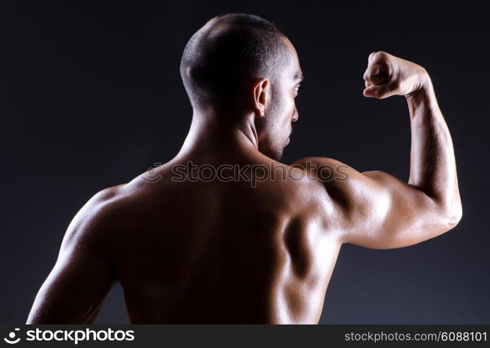 Muscular man in dark studio