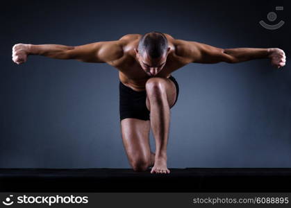 Muscular man in dark studio