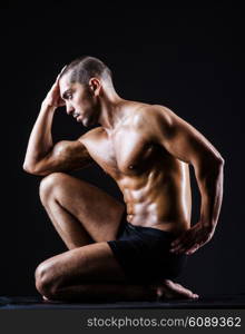 Muscular man in dark studio