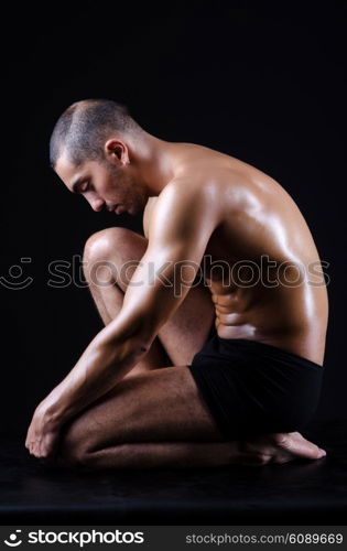 Muscular man in dark studio