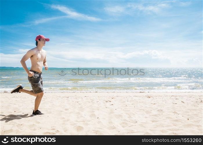 Muscular man is running on the beach