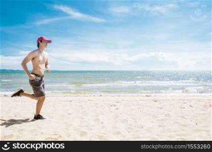 Muscular man is running on the beach