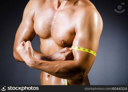 Muscular man measuring his muscles