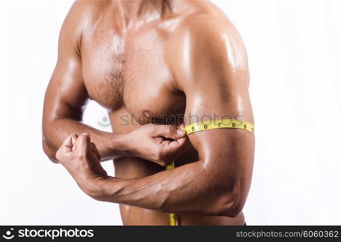Muscular man measuring his muscles