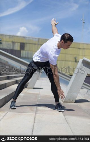 Muscular man stretching outdoors