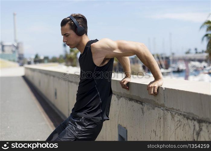Muscular man stretching outdoors