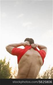 Muscular Man Taking Off His Shirt