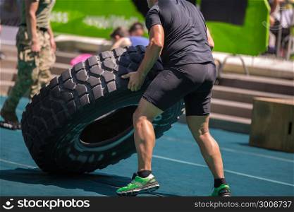Muscular Man Training: Soldiers Lift Huge and Heavy Truck Tire. Muscular Man Lift Huge and Heavy Truck Tire