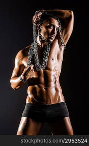 Muscular man with chain on black background